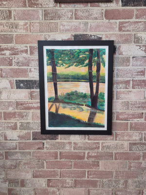 Before the Heat at White Rock Lake by Dawn Babcock, framed in black and hung on a brick wall
