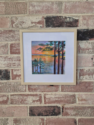 Linger by Dawn Babcock, framed in natural wood with a white mat, hung on a brick wall